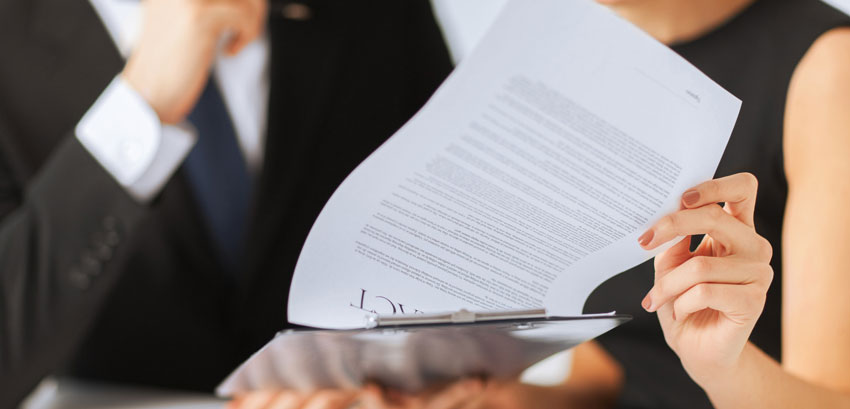 Business professionals reviewing and signing a contract