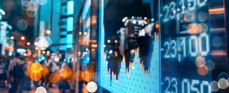 Digital stock ticker display reflecting a busy city street